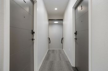 A long hallway with doors on both sides at The Avenue Lofts Golden Apartments, Golden